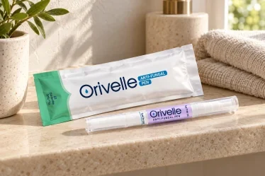 Penna Orivelle con la confezione su un ripiano chiaro accanto a un asciugamano